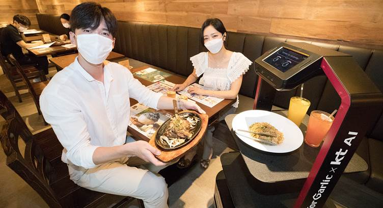 Models introduce an AI robot server at the Mad for Garlic restaurant in Hyundai I-Park Tower, Gangnam District, Seoul, South Korea, on September 1, 2020.